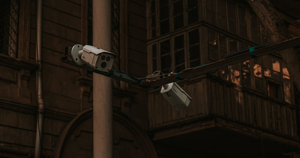 ANPR cameras location on a roadside pole monitoring passing vehicles at a suburban intersection at dusk