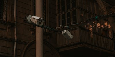 ANPR cameras location on a roadside pole monitoring passing vehicles at a suburban intersection at dusk