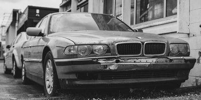 A dusty abandoned vehicle with flat tyres parked on a UK residential street awaiting DVLA and council action