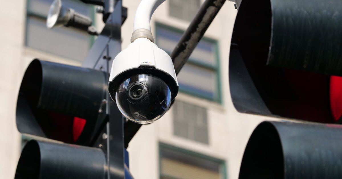 A roadside automated license plate reader camera at dusk, representing the Flock Safety class action surveillance lawsuits.