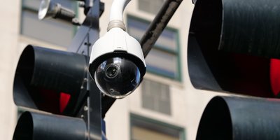 A roadside automated license plate reader camera at dusk, representing the Flock Safety class action surveillance lawsuits.
