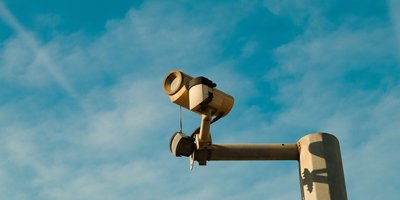 A Flock Safety ALPR camera mounted on a roadside pole, central to the flock safety lawsuit debate over mass surveillance