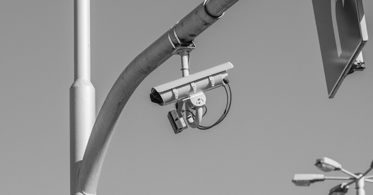 A Flock Safety automated license plate reader camera mounted on a pole, central to the ongoing flock security lawsuit debate.