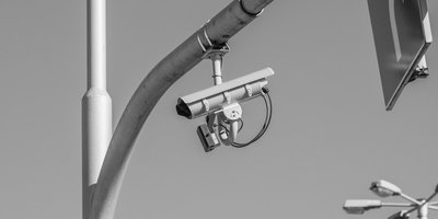 A Flock Safety automated license plate reader camera mounted on a pole, central to the ongoing flock security lawsuit debate.