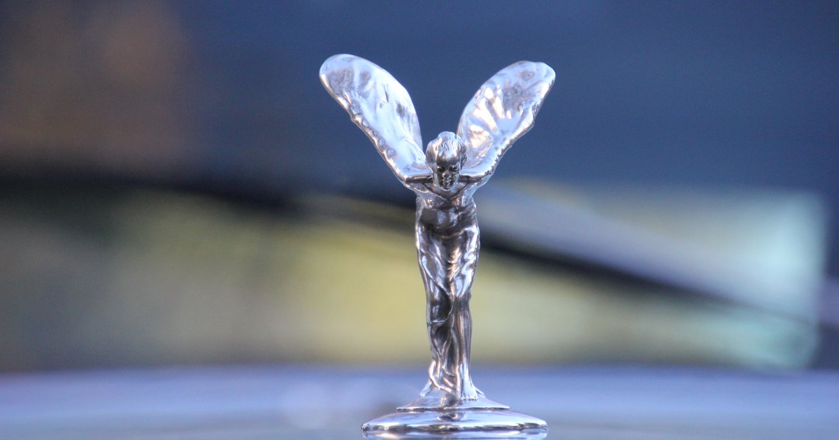 Close-up of a chrome hood ornament on a classic car, symbolizing personalization like a vanity plate