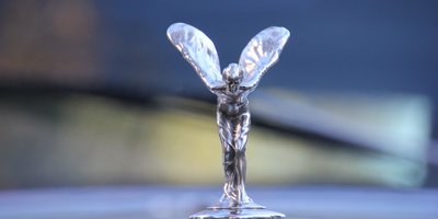 Close-up of a chrome hood ornament on a classic car, symbolizing personalization like a vanity plate