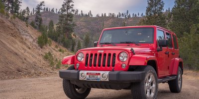Idaho license plate on a car near a mountain highway, illustrating an Idaho license plate lookup guide.