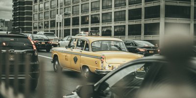 New York City street with parked cars showing license plates, illustrating an NYC license plate lookup.