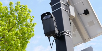 Automated license plate reader camera scanning a car, illustrating PlateQuery ALPR lookup history for free plate scan checks
