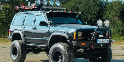 Close-up of a personalized TROLL vanity plate mounted on a lifted off-road vehicle bumper