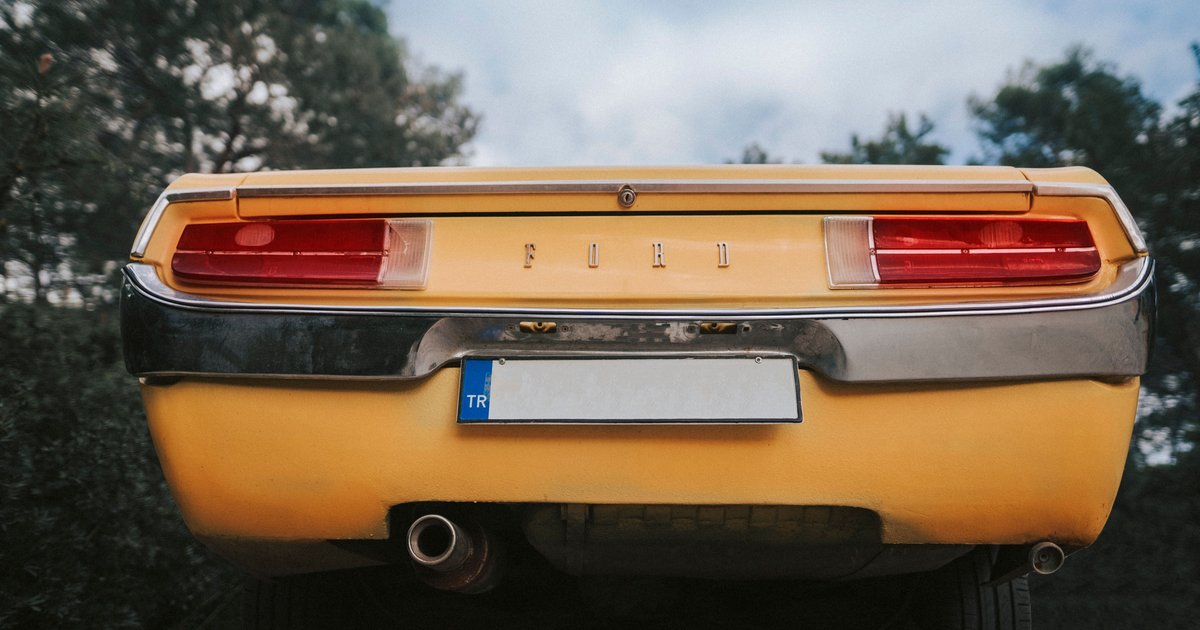 Close-up of a personalized vanity plate on the rear bumper of a parked car
